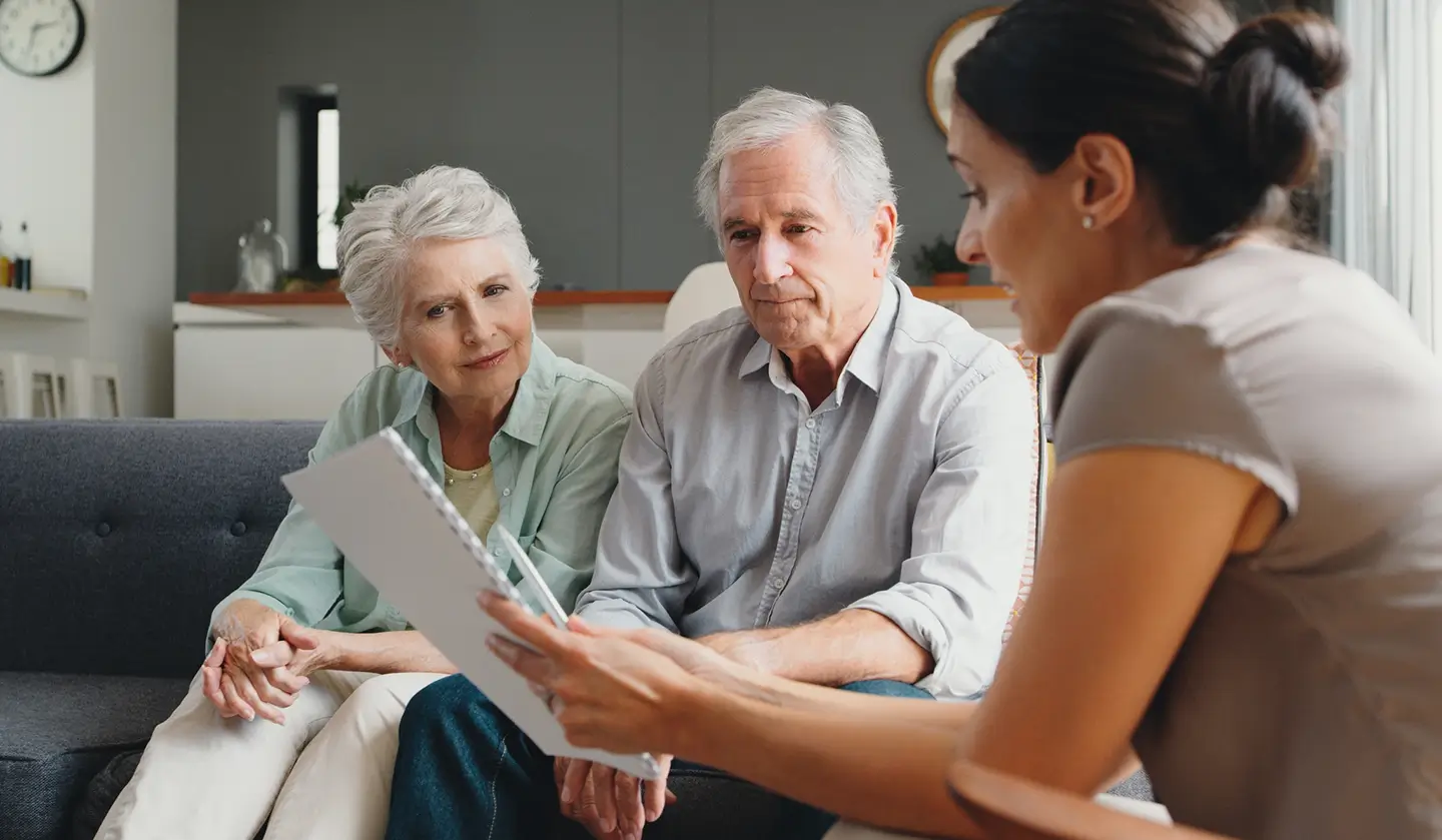 Couple discussing private home care in Edmonton with a professional caregiver